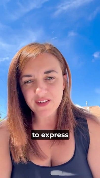 Woman recording a video outdoors beneath a blue sky